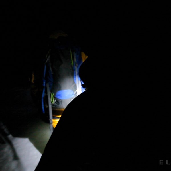 Cimbers walk in the dark with headlamps on a glacier