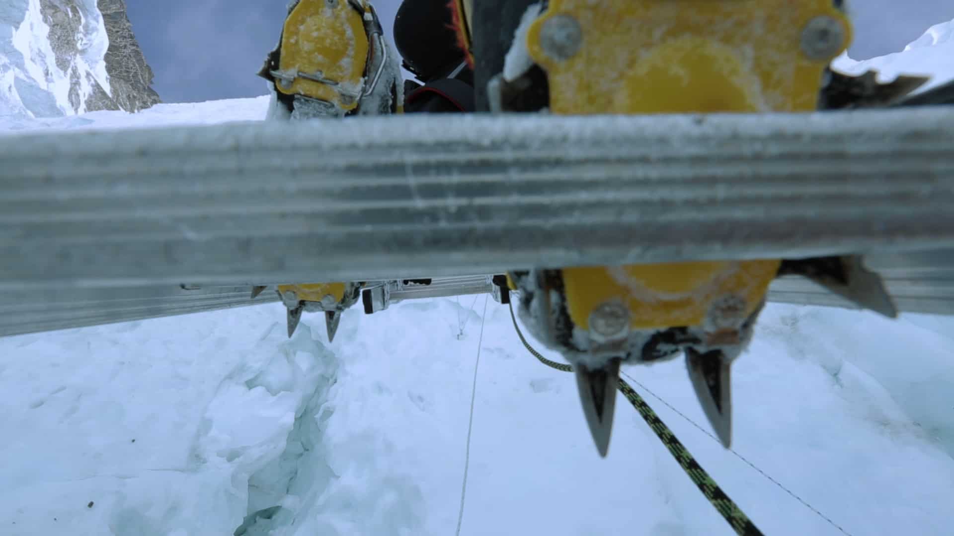 Sherpa descending a ladder on Everest in the Khumbu Icefall with unique